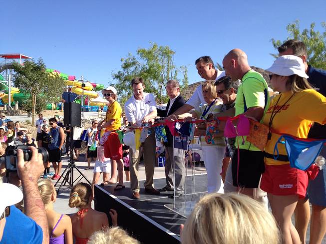 Tennis legend Andre Agassi, Clark County Commissioner Susan Brager and Wet 'n' Wild Las Vegas investors Roger and Scott Bulloch of SPB Partners prepare to cut a ceremonial red ribbon made fittingly of swimwear during the park's grand opening on Friday, May 24, 2013. Kids in candy-colored swimsuits squirmed anxiously during the ceremony as they waited for the green light to ride the slides.