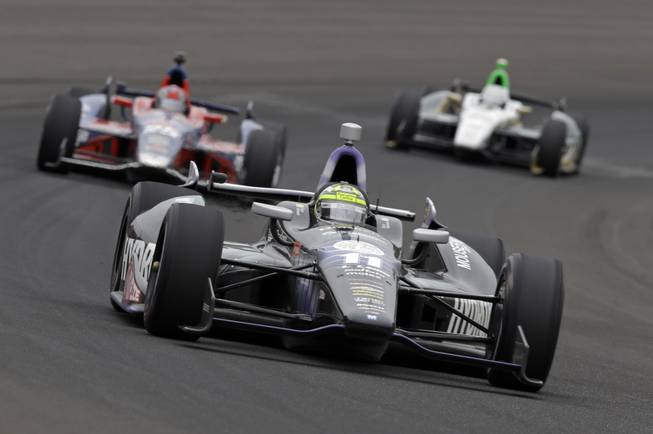 Tony Kanaan, of Brazil, drives through the first turn during the Indianapolis 500 auto race at the Indianapolis Motor Speedway in Indianapolis on Sunday, May 26, 2013. 