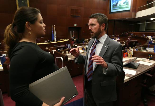 Nevada Assembly Democrats Teresa Benitez-Thompson and David Bobzien talk on the Assembly floor at the Legislative Building in Carson City, Nev., on Wednesday, April 10, 2013. Benitez-Thompson's Government Affairs committee approved Bobzien's bill to bar Pershing County from imposing regulations and fees on Burning Man. 