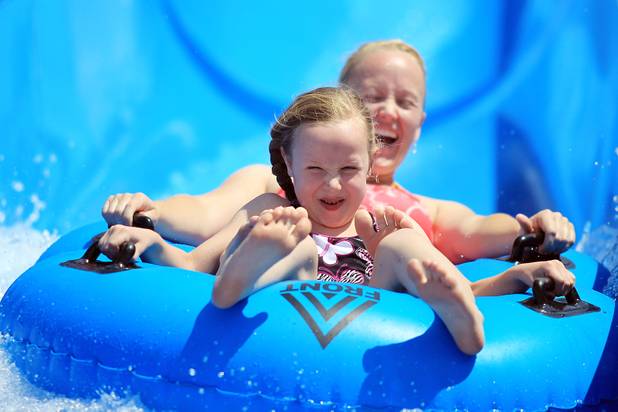 Abby Lung, 6, and her mother Alicia, both of Las Vegas, ride the Zip Zap Zoom water slide during the first day of general admission at Wet'n'Wild Las Vegas on Monday, June 3, 2013.