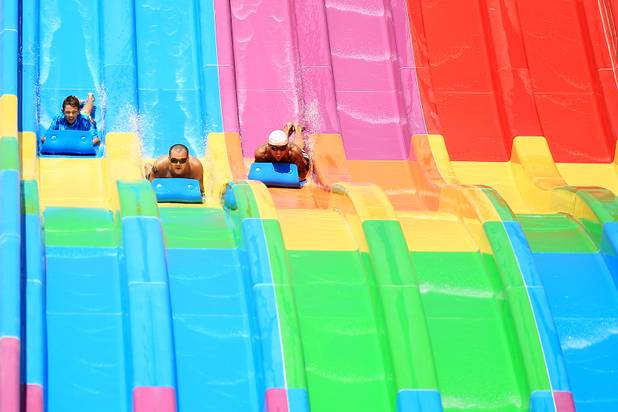 Guests race down the Desert Racer water slide during the first day of general admission at Wet'n'Wild Las Vegas on Monday, June 3, 2013.