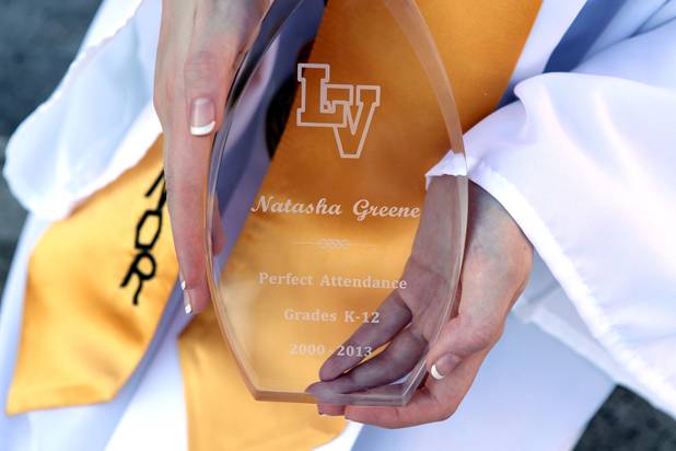 Las Vegas High School valedictorian Natasha Greene shows off her perfect attendance plaque during her commencement ceremony on the school's football field in Las Vegas on Friday, June 7, 2013. Greene has had perfect attendance and perfect grades since kindergarten.