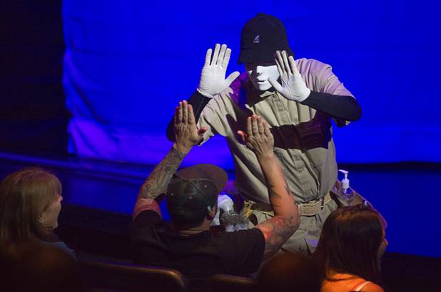 A Jabbawockeez cast member greets a member of the audience during in "Prism," their new show at the Luxor, Sunday, June 9, 2013.