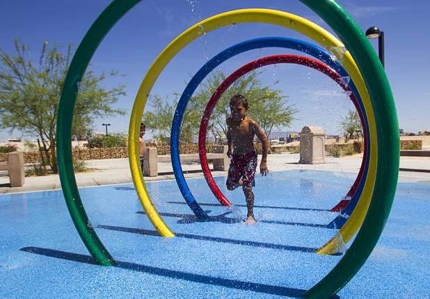 Dante Clemonts, 9, runs through a water feature at Charlie Frias Park Sunday, June 9, 2013. Sunday's high temperature was 109, two degrees shy of the record.