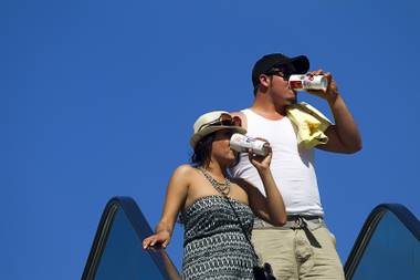 A couple keeps hydrated while visiting the Las Vegas Strip Sunday, June 9, 2013. Sunday’s high temperature was 109, two degrees shy of the record.