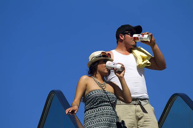 A couple keeps hydrated while visiting the Las Vegas Strip Sunday, June 9, 2013. Sunday's high temperature was 109, two degrees shy of the record.