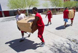Football players carry boxes of new equipment into Western High School Monday, June 10, 2013. The high school football programs at Chaparral and Western received donations of $500,000 to upgrade everything from the weight room to field equipment and new uniforms.