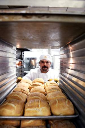 Baker Carlos Meza racks fresh bread inside the basement bakery at Caesars Palace in Las Vegas on Tuesday, June 11, 2013.