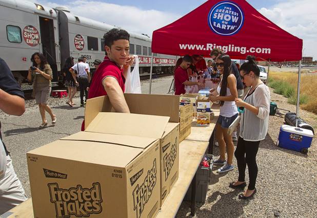 High wire artist Achraf El Kati of Morocco packs a food backpack outside the Ringling Bros. and Barnum & Bailey Circus train Wednesday, June 12, 2013. Circus performers teamed up with the Three Square Food Bank to pack 100 food backpacks for local families. The circus opens Thursday at the Thomas & Mack Center and runs through Sunday.