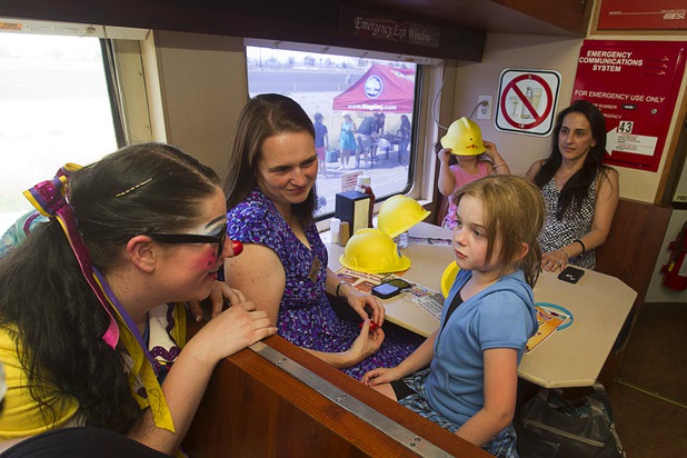 Clown Genevieve "G" Flati talks with Allison Collumb, 6, on the Ringling Bros. and Barnum & Bailey Circus train's dining car Wednesday, June 12, 2013. Kate McLaughlin, Collumb's mother and a Three Square Food Bank childhood nutrition coordinator, looks on at center. Circus performers and staff teamed up with the Three Square Food Bank to pack 100 food backpacks for local families. The circus opens Thursday at the Thomas & Mack Center and runs through Sunday.