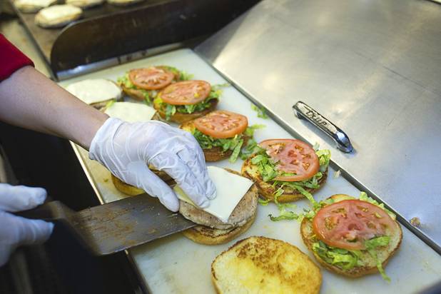 Colleen Doyle makes turkey burgers on the "Pie Car," the dining car on the Ringling Bros. and Barnum & Bailey Circus train, Wednesday, June 12, 2013. Circus performers teamed up with the Three Square Food Bank to pack 100 food backpacks for local families and hosted Three Square families with lunch on the Pie Car. The circus opens Thursday at the Thomas & Mack Center and runs through Sunday.