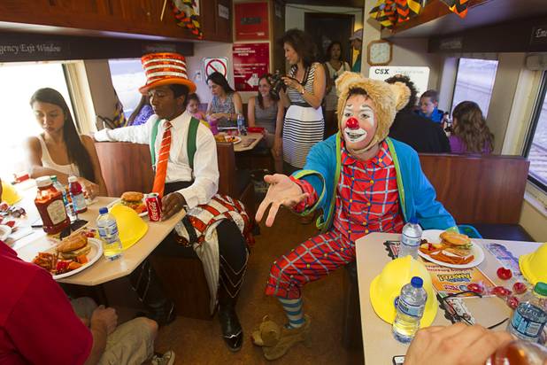 Clown Aaron Crane tosses a sweet potato fry to another clown on the Ringling Bros. and Barnum & Bailey Circus train's "Pie Car" Wednesday, June 12, 2013. Circus performers teamed up with the Three Square Food Bank to pack 100 food backpacks for local families and hosted Three Square families with a lunch on the Pie Car. The circus opens Thursday at the Thomas & Mack Center and runs through Sunday.