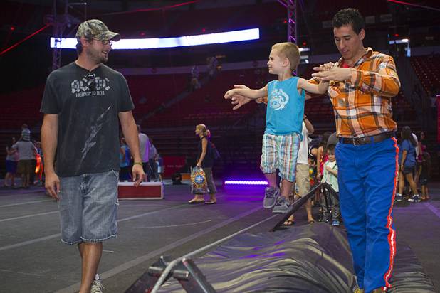 Chris Slavens, left, watches as his son Landon, 3, tries out as a tight rope walker during a pre-show on the opening night of the Ringling Bros. and Barnum & Bailey Circus at the Thomas & Mack Center Thursday, June 13, 2013. The "Built to Amaze!" tour runs through Sunday, June 16.