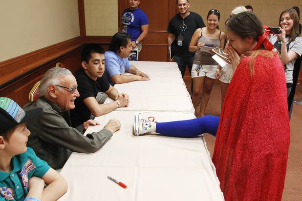 Veronica Fink reacts as she puts her foot on the table to have comic legend Stan Lee sign her shoe at the Amazing Las Vegas Comic Con at the South Point Saturday, June 15, 2013.