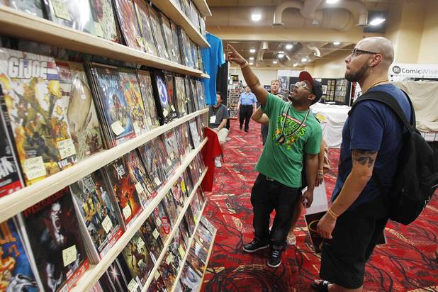 D. Brown, left, and Matthias Strife look at a selection of comic books at the Amazing Las Vegas Comic Con at the South Point Saturday, June 15, 2013.