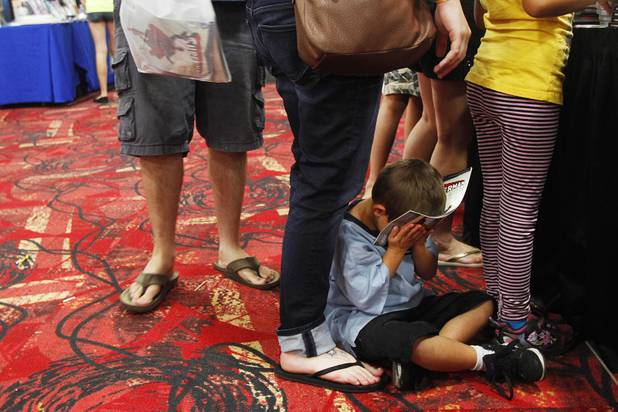 A young attendee buries his head at the Amazing Las Vegas Comic Con at the South Point Saturday, June 15, 2013.