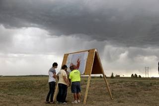 Residents look at a map detailing the progress of the Black Forest wildfire Sunday, June 16, 2013, in Colorado Springs, Colo. Fire crews were putting out hot spots Sunday to prevent flare ups in heavily wooded Black Forest, where hundreds of houses have been destroyed.