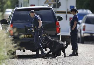 Law enforcement officials from the Michigan State Police help search the area in Oakland Township, Mich., Tuesday, June 18, 2013 where officials continue the search for the remains of Teamsters union president Jimmy Hoffa who disappeared from a Detroit-area restaurant in 1975.