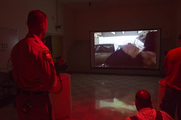Metro Police Officer Fred Oliveri, left, watches as a subject on video charges during a demonstration of a MILO training system at the Metro Police training facility Wednesday, June 19, 2013. MILO (Multiple Interactive Learning Objectives) is a interactive training system for cadets and officers. With the recent passage of the "More Cops" bill, Metro Police announced they will soon hold the first police academy since January 2012.