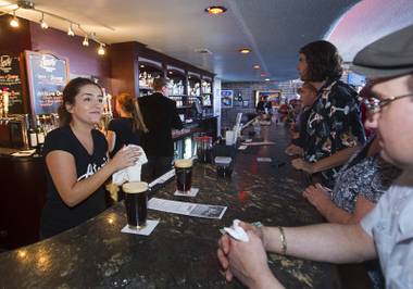 Bartender Ashlea Latham, left, serves drinks during the grand reopening of The Atomic on East Fremont Street Wednesday, June 20, 2013. The bar was originally built in 1945 as Virginia’s Cafe but was renamed Atomic Liquors in 1952 when patrons used to go to the roof to watch the nuclear blasts from the Atomic Test Site.