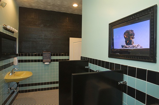 A video monitor in the men's room shows atomic blasts and "duck-and-cover" videos at The Atomic on East Fremont Street Wednesday, June 20, 2013. The bar was originally opened in 1945 as Virginia's Cafe but was renamed Atomic Liquors in 1952 when patrons used to go to the roof to watch the nuclear blasts from the Atomic Test Site.