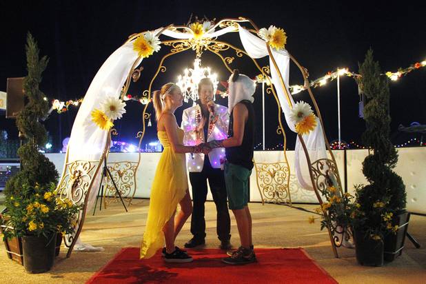 Brian Mills officiates as Shacura and Charles Mendoza exchange wedding vows during the first night of the Electric Daisy Carnival Friday, June 21, 2013 at the Las Vegas Motor Speedway.