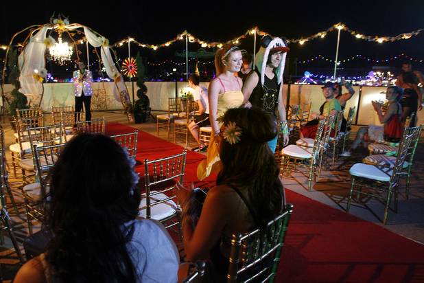 Shacura and Charles Mendoza walk down the aisle after exchanging wedding vows during the first night of the Electric Daisy Carnival Friday, June 21, 2013 at the Las Vegas Motor Speedway.