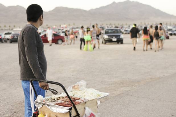 A food vendor selling hot dogs in the parking lot watches festival-goers leave at the end of day two of the Electric Daisy Carnival festival at the Las Vegas Motor Speedway, Sunday morning, June 23, 2013.