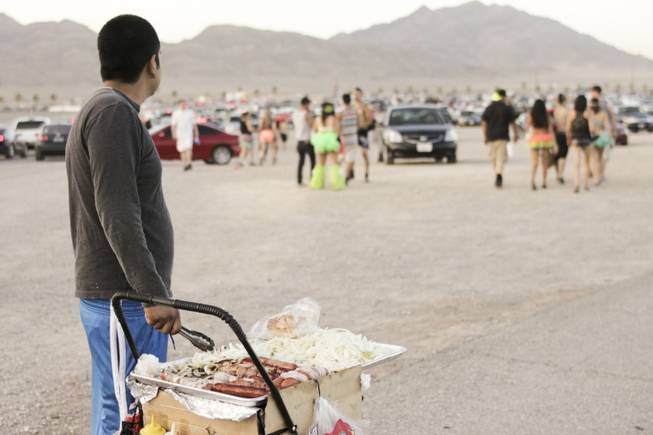 A food vendor selling hot dogs in the parking lot watches festival-goers leave at the end of day two of the Electric Daisy Carnival festival at the Las Vegas Motor Speedway, Sunday morning, June 23, 2013.