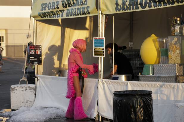A fan is seen buying a drink as the sun rises at the end of day two of the Electric Daisy Carnival Festival, EDC, at the Las Vegas Motor Speedway, Sunday morning, June 23, 2013.