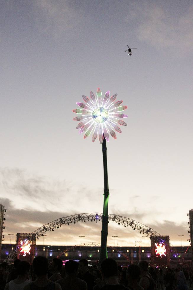 A helicopter flies by a giant daisy at the Electric Daisy Carnival Festival, EDC, at the Las Vegas Motor Speedway, Sunday morning, June 23, 2013.
