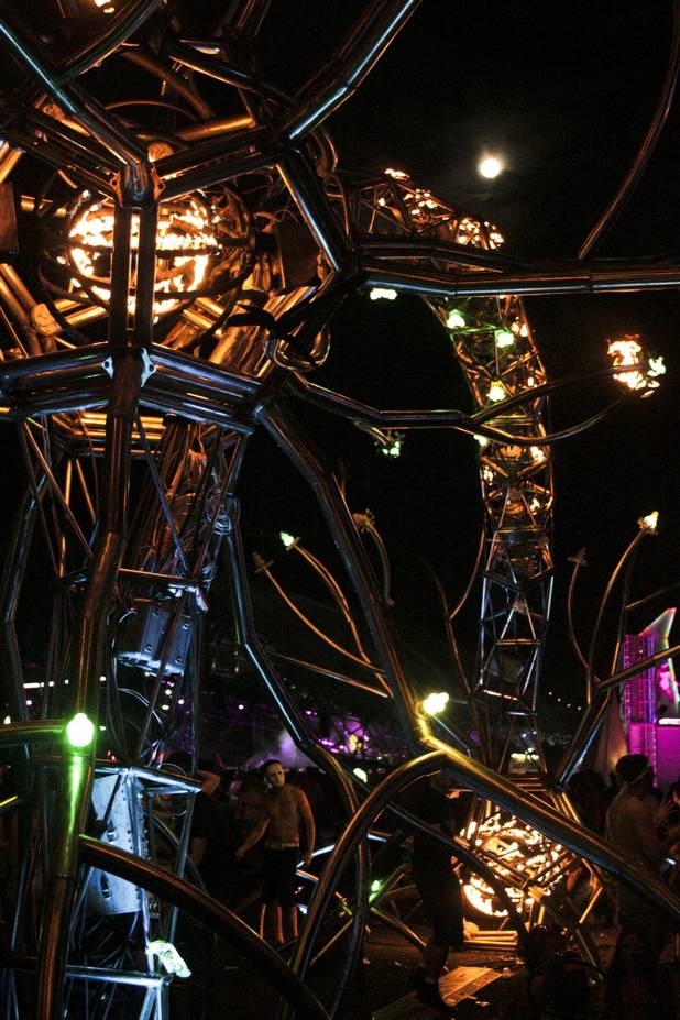 The full moon is seen behind a fire art installation at the Electric Daisy Carnival Festival, EDC, at the Las Vegas Motor Speedway, Sunday morning, June 23, 2013.