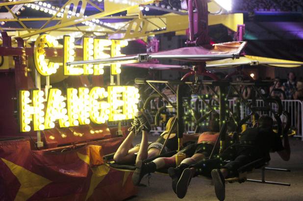 Festival attendees strap into the Cliff Hanger carnival ride at the Electric Daisy Carnival Festival, EDC, at the Las Vegas Motor Speedway, Sunday morning, June 23, 2013.