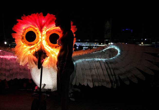 A festival goer stands in front of a lit owl bicycle at the Electric Daisy Carnival Festival, EDC, at the Las Vegas Motor Speedway, Sunday morning, June 23, 2013.