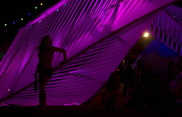 A festival-goer is silhouetted by a illuminated sculpture during the third day of the Electric Daisy Carnival at the Las Vegas Motor Speedway Sunday, June 23, 2013.