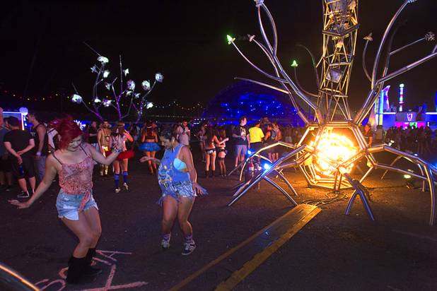 Women dance by "Soma," a sculpture by the San Francisco-based Flaming Lotus Girls, during the third day of the Electric Daisy Carnival at the Las Vegas Motor Speedway Sunday, June 23, 2013.