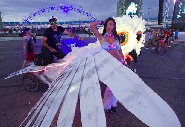 Anita SassyVong, 23, of Dallas poses by a owl bike ridden by Grant Schaubhut during the third day of the Electric Daisy Carnival at the Las Vegas Motor Speedway Sunday, June 23, 2013.