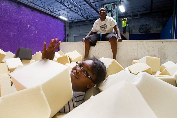Akayla Ryaborn, 12, a member of the Victory Baptist Church STARS Youth Ministry, waves after jumping into a foam pit at the Hardkore Parkour (HKPK) gym, 3680 N. 5th St., Thursday, June 27, 2013.