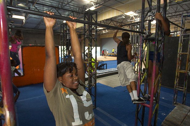 Destiny Matthews, 16, a member of the Victory Baptist Church STARS Youth Ministry, hangs from a bar at the Hardkore Parkour (HKPK) gym, 3680 N. 5th St., Thursday, June 27, 2013.