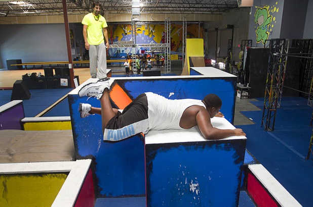 Instructor Nico Matinata watches as Keijon Braxton, 13, a member of the Victory Baptist Church STARS Youth Ministry, climbs onto a block at the Hardkore Parkour (HKPK) gym, 3680 N. 5th St., Thursday, June 27, 2013.