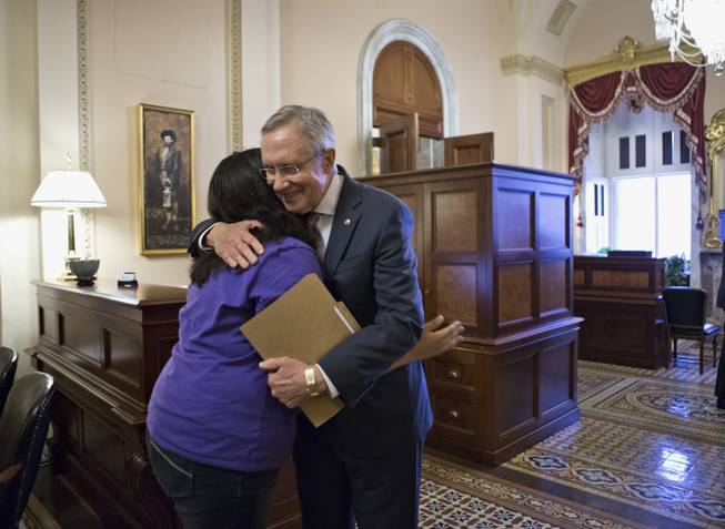 Senate Majority Leader Harry Reid of Nevada embraces Astrid Silva, of Las Vegas, a DREAM Act supporter whose family came to the U.S. from Mexico illegally and whose story has been an inspiration for Reid during work on the immigration reform bill, Thursday, June 27, 2013, on Capitol Hill in Washington. Reid carries a folder with letters from Astrid Silva that he read on the Senate floor before the historic vote.