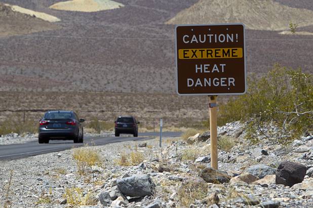 A sign warns of extreme heat as tourists enter Death Valley National Park Saturday, June 29, 2013.
