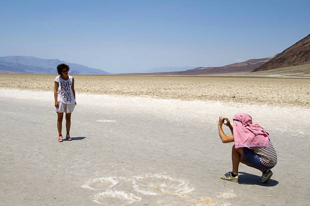 Elisabetta Delrio of Italy poses for her husband Nicola Capelli at Badwater Basin, 282 feet (85.5m) below sea level, as high temperatures approach record numbers in Death Valley National Park Saturday, June 29, 2013.