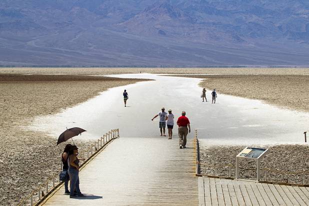 A pair of women use an umbrella for shade at Badwater Basin, 282 feet (85.5m) below sea level, in Death Valley National Park Saturday, June 29, 2013.