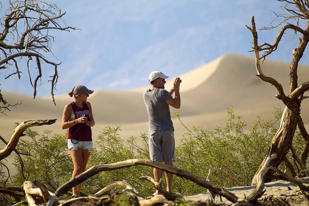 Julia Schmid, left, and Vincent Wilhelm of Switzerland the photos of the Mesquite Dunes as high temperatures approach record numbers in Death Valley National Park Saturday, June 29, 2013.