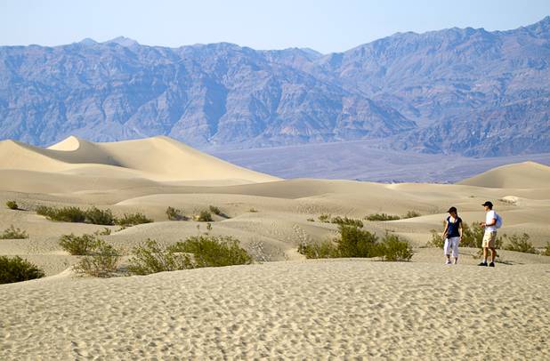 Sara Calcinaro, left, and Marco Rizzelli of Italy walk in the Mesquite Dunes as high temperatures approach record numbers in Death Valley National Park Saturday, June 29, 2013.