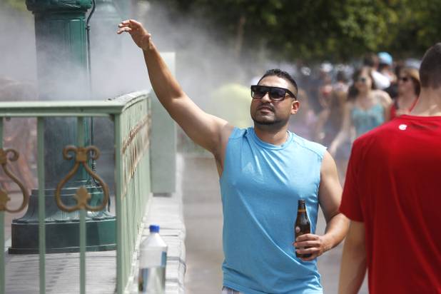 A tourist takes advantage of the misters at Mon Ami Gabi at Paris Las Vegas on Saturday, June 29, 2013.