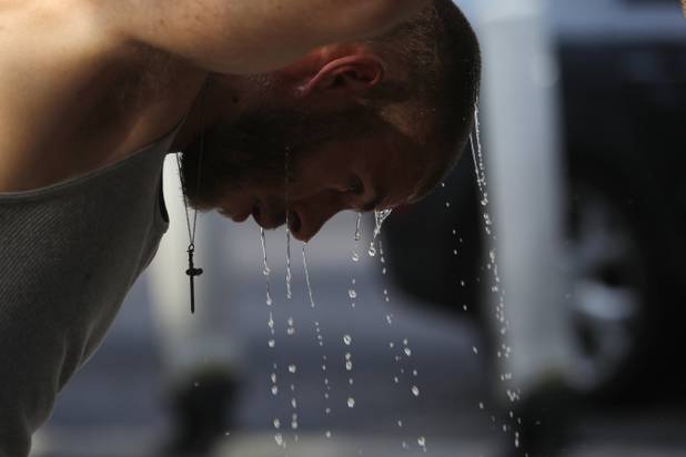 Spencer Suggars douses his head with water on the Strip Saturday, June 29, 2013.