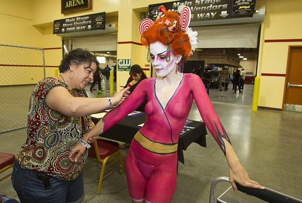 Body paint artist Suzanne Lugano works on Wonka-esque geisha-look for model Sarah Jane Woodall during the inaugural Art N Ink Festival at the South Point Sunday, June 30, 2013.