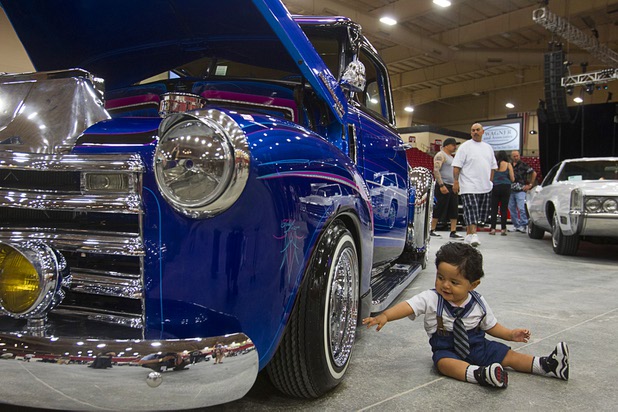 Jayden Bedoy, 10-months, reaches to a customized 1949 Chevrolet 3100 pick-up truck during the inaugural Art N Ink Festival at the South Point Sunday, June 30, 2013.